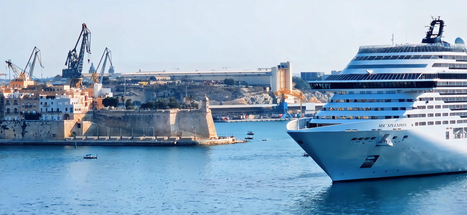A cruise liner sailing past the historic fortifications of Malta's Grand Harbour